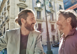 Zwei Männer stehen an der Straße und unterhalten sich.