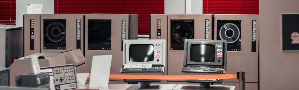 Foto von alten Computern und Rechnern. Man sieht, wie groß die Rechner früher waren und wie klein die die Bildschirme.